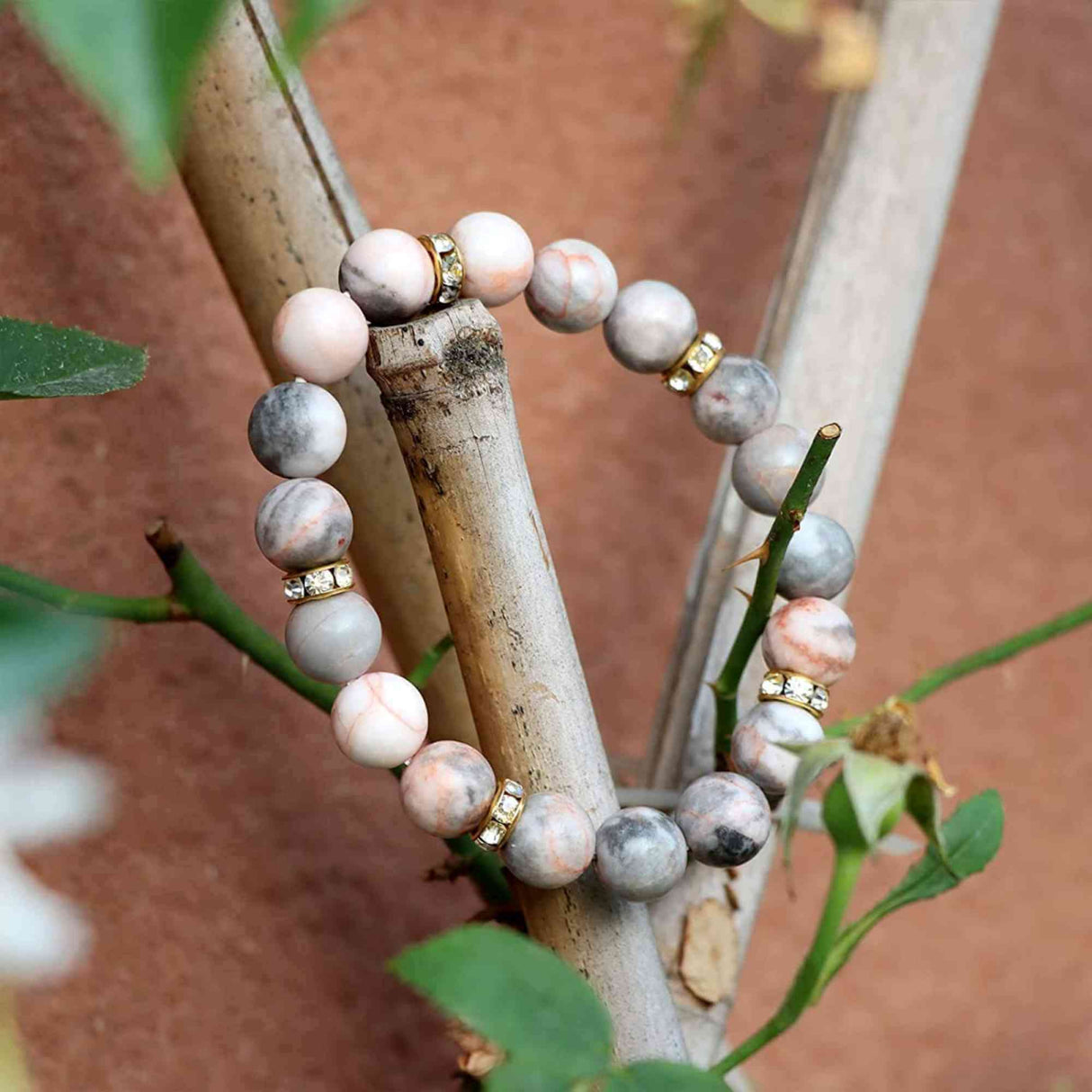 Bratara elastica cu pietre semipretioase zebra stone roz de 10 si 5 mm cu margele aurii si strasuri